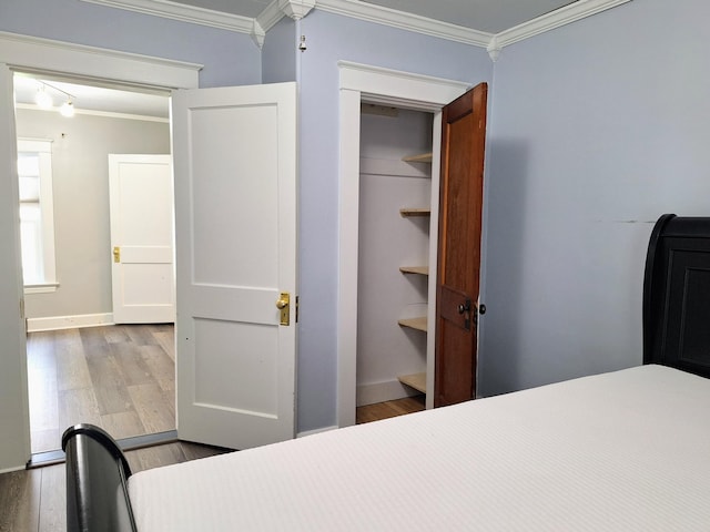 bedroom featuring crown molding, wood finished floors, and baseboards