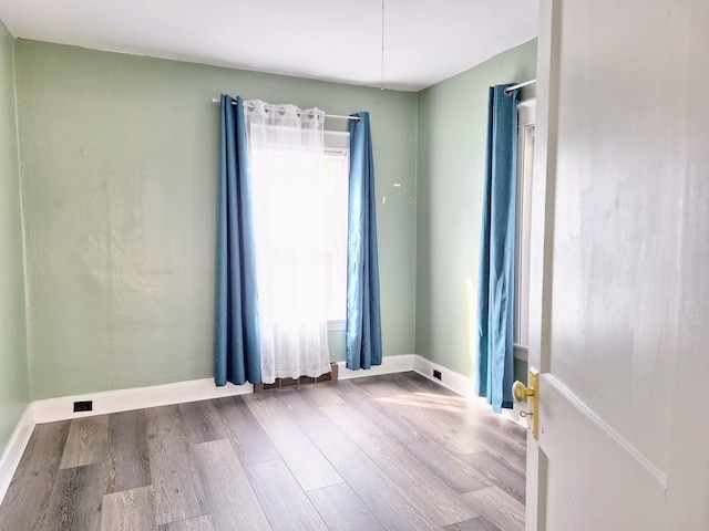 unfurnished room with wood finished floors and baseboards