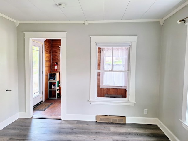 unfurnished room featuring ornamental molding, healthy amount of natural light, a smoke detector, and dark wood finished floors