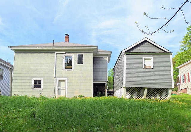 back of house featuring a chimney