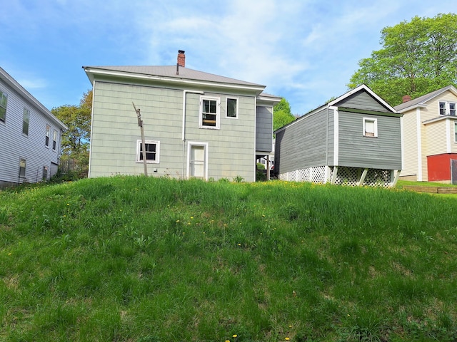back of house with a chimney