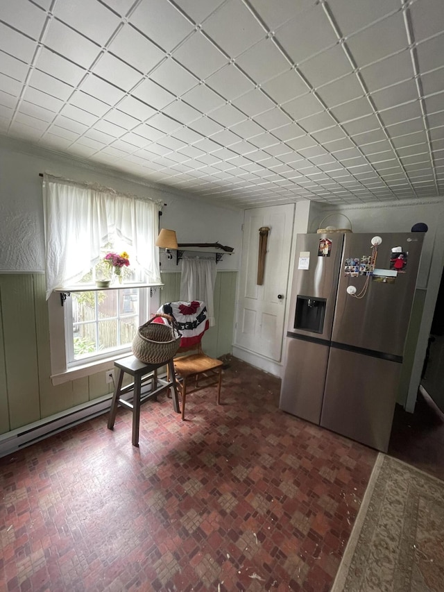27 Murray St, Bingham, ME 04920 - living area with a baseboard radiator, brick patterned floors, and a wainscoted wall