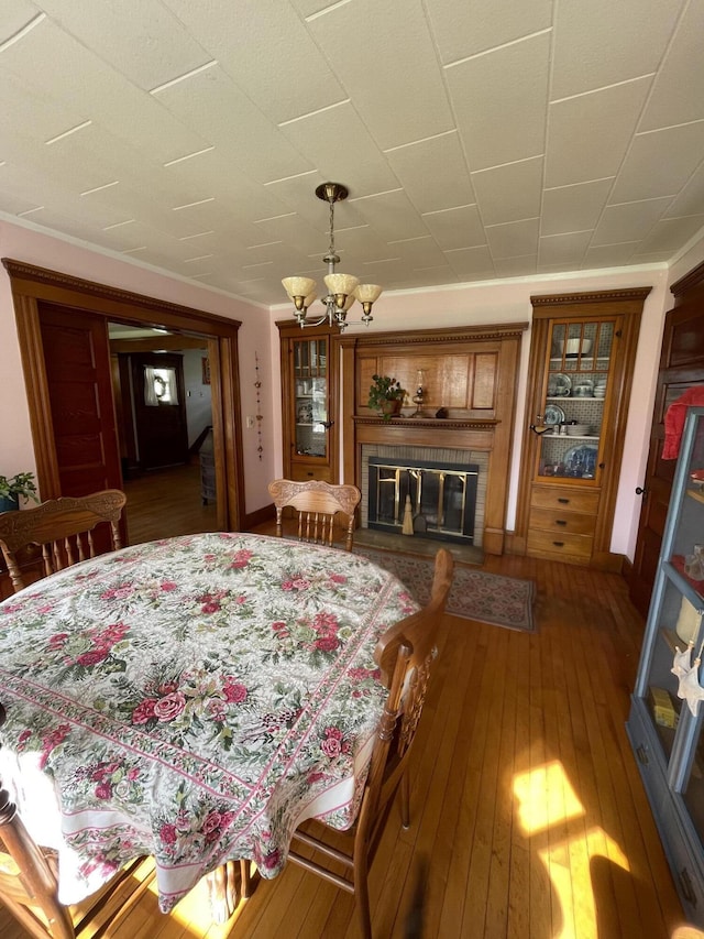 27 Murray St, Bingham, ME 04920 - dining room with hardwood / wood-style flooring, a chandelier, and a glass covered fireplace