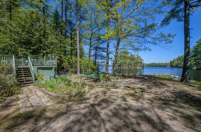 19 Pulpit Rock Rd, Raymond, ME 04071 - view of yard with stairway, a deck with water view, and a wooded view
