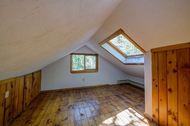 19 Pulpit Rock Rd, Raymond, ME 04071 - additional living space with baseboard heating, hardwood / wood-style flooring, a skylight, lofted ceiling, and a textured ceiling