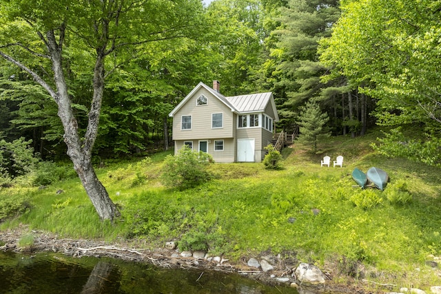 67 Day Mountain Rd, Temple, ME 04984 - view of property exterior with a chimney, a metal roof, a view of trees, and a water view
