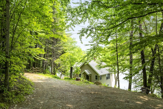 67 Day Mountain Rd, Temple, ME 04984 - view of property exterior with a metal roof, a standing seam roof, a wooded view, and driveway