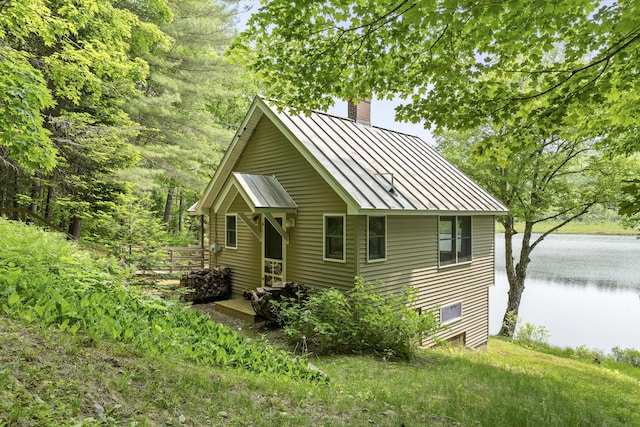 67 Day Mountain Rd, Temple, ME 04984 - view of front of house with a standing seam roof, a chimney, a metal roof, and a water view