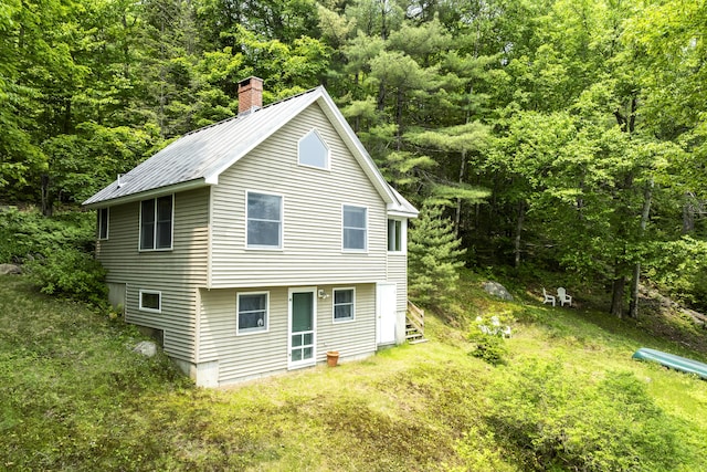 67 Day Mountain Rd, Temple, ME 04984 - view of home's exterior with a metal roof, a chimney, and a view of trees