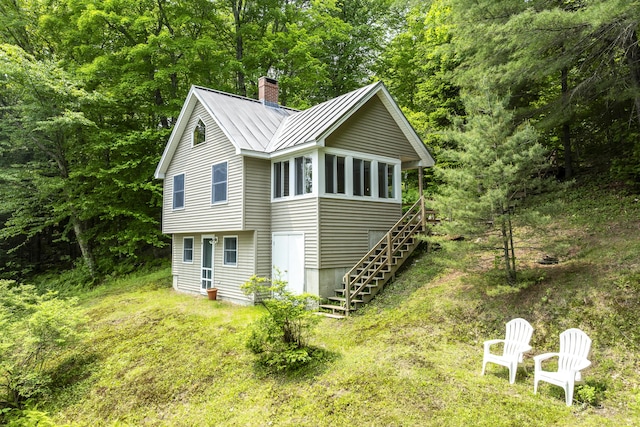 67 Day Mountain Rd, Temple, ME 04984 - view of side of property with a chimney, stairs, a metal roof, a standing seam roof, and a wooded view