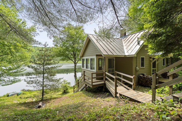 67 Day Mountain Rd, Temple, ME 04984 - view of side of home with a standing seam roof, a water view, stairs, a metal roof, and a chimney