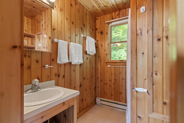 67 Day Mountain Rd, Temple, ME 04984 - bathroom featuring a baseboard radiator, wooden walls, vanity, and wooden ceiling