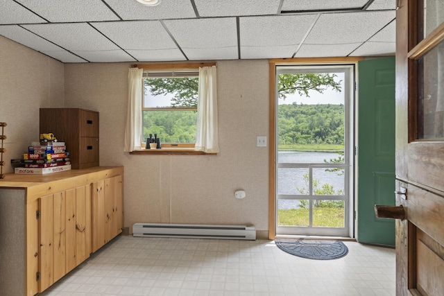 67 Day Mountain Rd, Temple, ME 04984 - doorway featuring baseboard heating, light floors, healthy amount of natural light, and a paneled ceiling