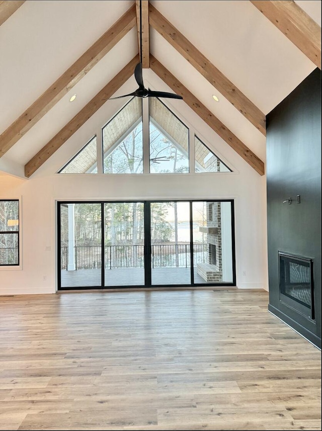 80 Indian Rivers Dr, Eliot, ME 03903 - unfurnished living room featuring beam ceiling, high vaulted ceiling, a large fireplace, recessed lighting, and light wood-style floors