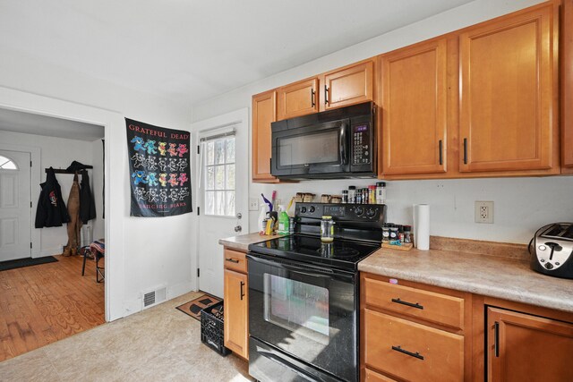19 Brann Ave, Augusta, ME 04330 - kitchen with black appliances, light countertops, and brown cabinets