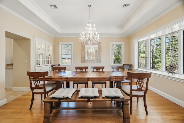 1026 Essex St, Bangor, ME 04401 - dining room with a chandelier, baseboards, a raised ceiling, light wood-type flooring, and ornamental molding