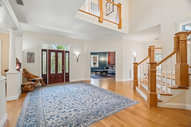 1026 Essex St, Bangor, ME 04401 - foyer featuring light wood-type flooring, healthy amount of natural light, decorative columns, stairs, and ornamental molding
