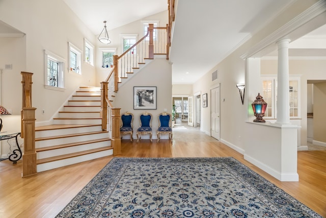 1026 Essex St, Bangor, ME 04401 - entryway with wood finished floors, stairway, baseboards, ornate columns, and a towering ceiling
