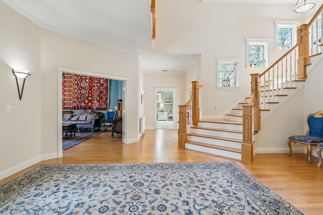 1026 Essex St, Bangor, ME 04401 - foyer with wood finished floors, plenty of natural light, stairway, crown molding, and a towering ceiling