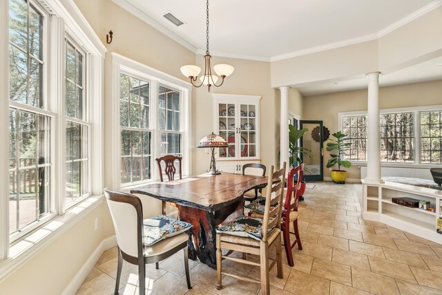 1026 Essex St, Bangor, ME 04401 - dining room with ornate columns, ornamental molding, stone tile flooring, a chandelier, and baseboards