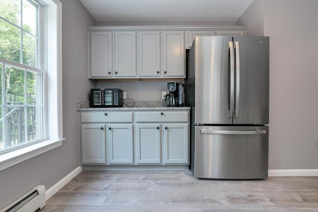 313 Nevells Way, Ellsworth, ME 04605 - kitchen featuring freestanding refrigerator, a baseboard radiator, baseboards, and light stone counters