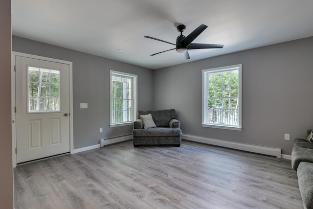 313 Nevells Way, Ellsworth, ME 04605 - living area featuring a baseboard heating unit, light wood-style floors, and baseboards