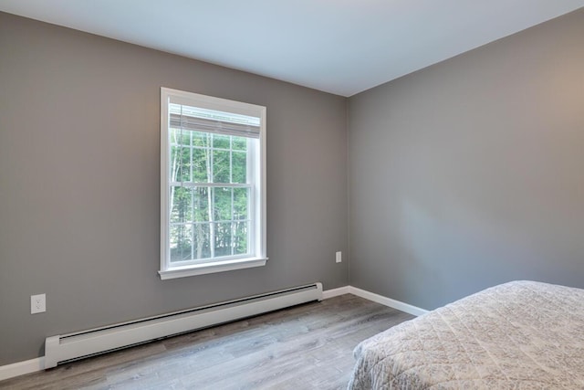 313 Nevells Way, Ellsworth, ME 04605 - unfurnished bedroom with a baseboard heating unit, wood finished floors, and baseboards