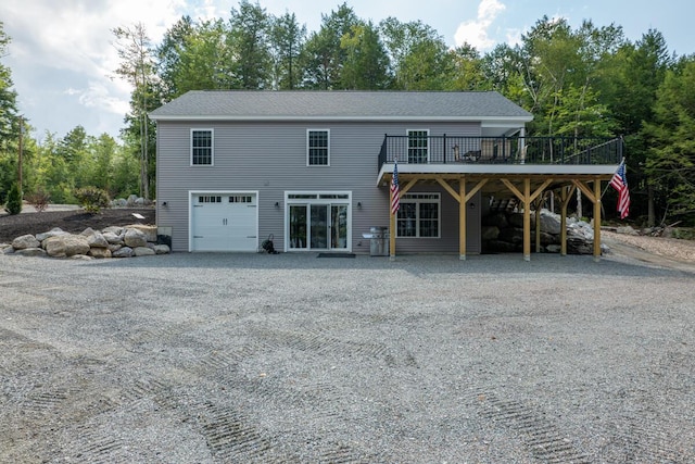 313 Nevells Way, Ellsworth, ME 04605 - rear view of house with a wooden deck, gravel driveway, and an attached garage