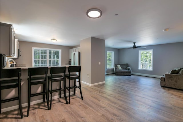 313 Nevells Way, Ellsworth, ME 04605 - kitchen with freestanding refrigerator, a breakfast bar, a baseboard radiator, and plenty of natural light
