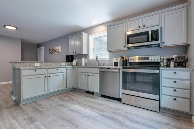 313 Nevells Way, Ellsworth, ME 04605 - kitchen with appliances with stainless steel finishes, a peninsula, light wood-style flooring, light stone counters, and recessed lighting