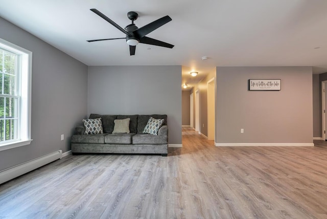 313 Nevells Way, Ellsworth, ME 04605 - living area featuring baseboard heating, wood finished floors, a ceiling fan, and baseboards