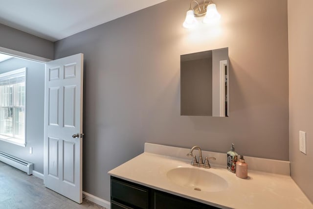 313 Nevells Way, Ellsworth, ME 04605 - bathroom with baseboard heating, vanity, wood finished floors, and baseboards