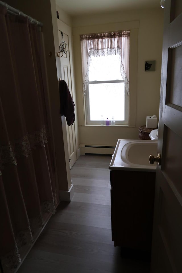 11 Green St, Winthrop, ME 04364 - full bath featuring baseboard heating, vanity, wood finished floors, and curtained shower
