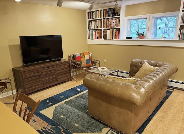 living room with rail lighting, wood finished floors, and baseboard heating
