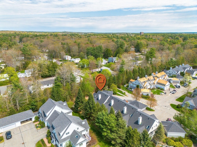 aerial view of property and surrounding area featuring nearby suburban area and a forest