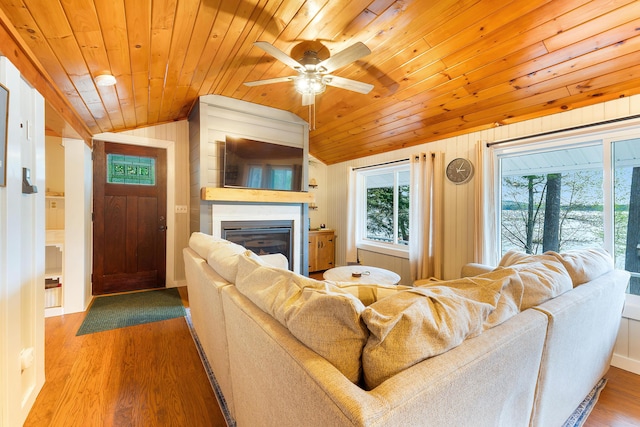 61 Beechwoods Rd, Oxford, ME 04270 - living area with lofted ceiling, wood ceiling, a glass covered fireplace, a ceiling fan, and wood finished floors