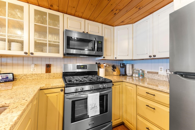 61 Beechwoods Rd, Oxford, ME 04270 - kitchen featuring stainless steel appliances, wooden ceiling, glass insert cabinets, white cabinetry, and light stone countertops