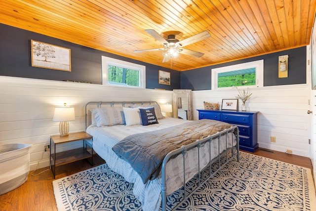 61 Beechwoods Rd, Oxford, ME 04270 - bedroom with wood ceiling, multiple windows, a wainscoted wall, wood finished floors, and ceiling fan