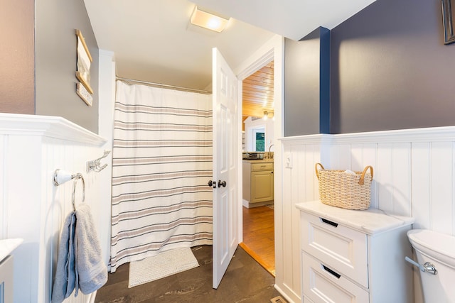 61 Beechwoods Rd, Oxford, ME 04270 - bathroom with a wainscoted wall, a decorative wall, toilet, vanity, and curtained shower