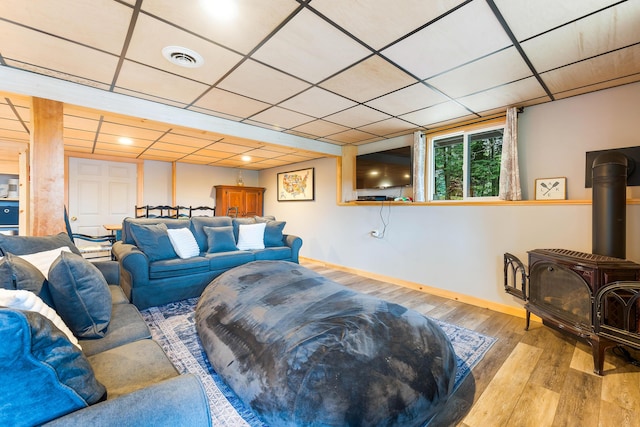 61 Beechwoods Rd, Oxford, ME 04270 - living room with a wood stove, wood finished floors, a paneled ceiling, and baseboards