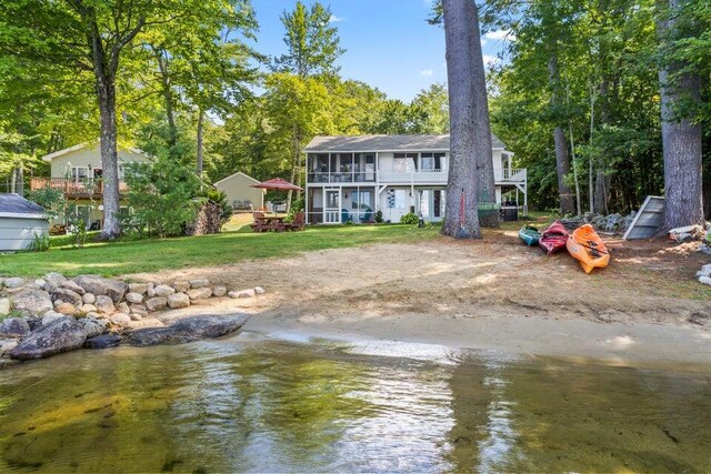 61 Beechwoods Rd, Oxford, ME 04270 - rear view of property with a sunroom, a balcony, a lawn, a water view, and view of scattered trees