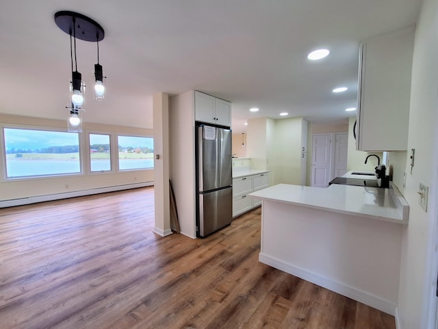 58 Back Shore Rd, Castine, ME 04421 - kitchen featuring freestanding refrigerator, a baseboard heating unit, a sink, wood finished floors, and light countertops