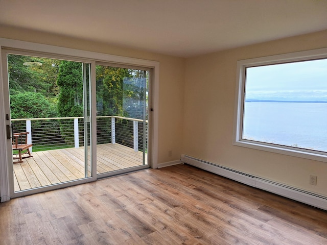 58 Back Shore Rd, Castine, ME 04421 - empty room featuring a baseboard radiator, plenty of natural light, wood finished floors, and baseboards