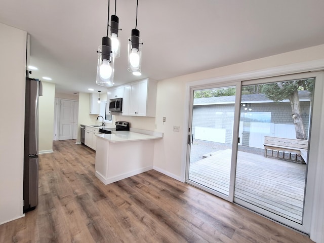 58 Back Shore Rd, Castine, ME 04421 - kitchen with stainless steel appliances, light wood-style floors, light countertops, baseboards, and white cabinetry