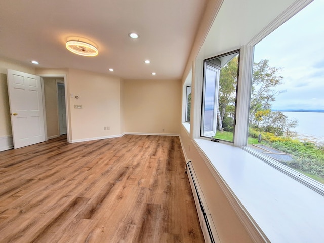 58 Back Shore Rd, Castine, ME 04421 - empty room featuring recessed lighting, a water view, light wood-style floors, a baseboard heating unit, and baseboards