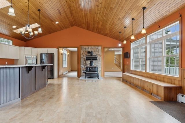 20 Motorcycle Dr, Windham, ME 04062 - kitchen featuring stainless steel appliances, a wood stove, vaulted ceiling, light countertops, and plenty of natural light