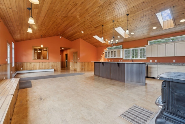 20 Motorcycle Dr, Windham, ME 04062 - kitchen featuring a skylight, wainscoting, vaulted ceiling, a baseboard radiator, and a kitchen breakfast bar