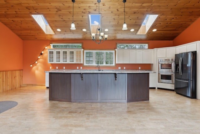 20 Motorcycle Dr, Windham, ME 04062 - kitchen featuring appliances with stainless steel finishes, a skylight, wooden ceiling, white cabinets, and a breakfast bar