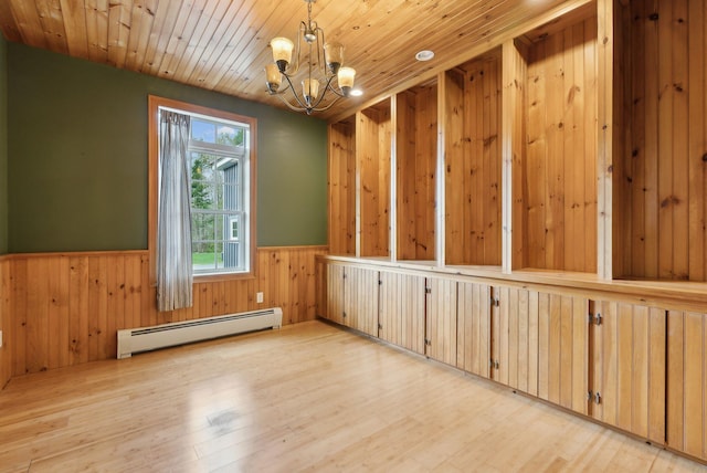 20 Motorcycle Dr, Windham, ME 04062 - spare room with a baseboard heating unit, a wainscoted wall, a chandelier, wood walls, and light wood finished floors