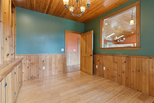 20 Motorcycle Dr, Windham, ME 04062 - unfurnished room featuring a chandelier, a wainscoted wall, wood walls, and wood finished floors